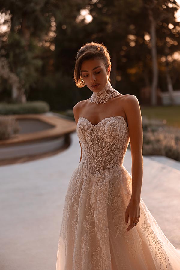 Junge Frau mit elegantem Spitzenkleid und nachdenklichem Blick in sanftem Abendlicht