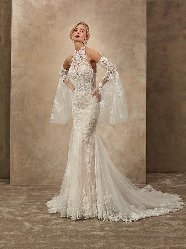 Eine blonde Frau mit ernster Miene trägt ein figurbetontes cremefarbenes Spitzenkleid