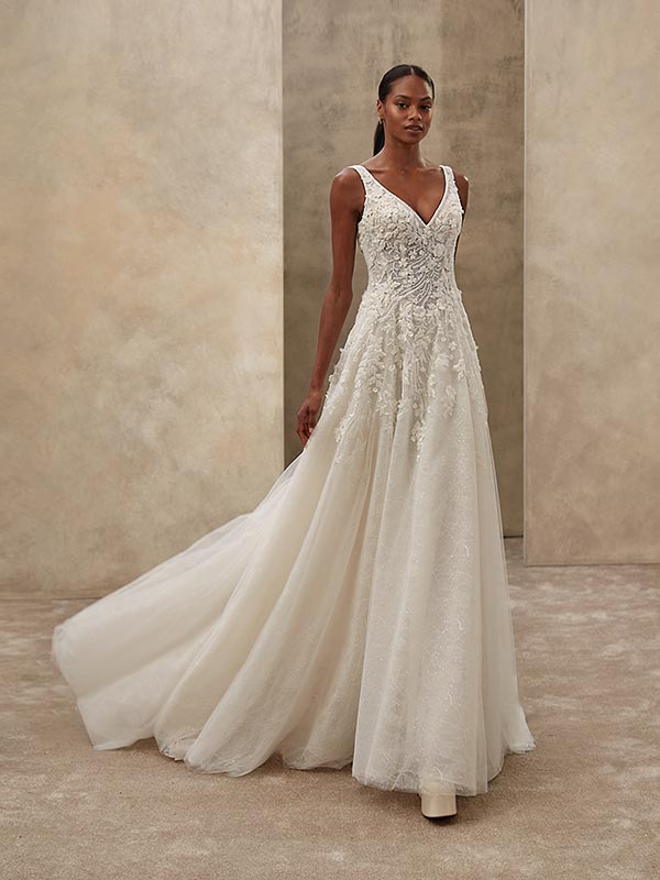 Eine Frau mit elegantem Gesichtsausdruck trägt ein weißes, verziertes Brautkleid