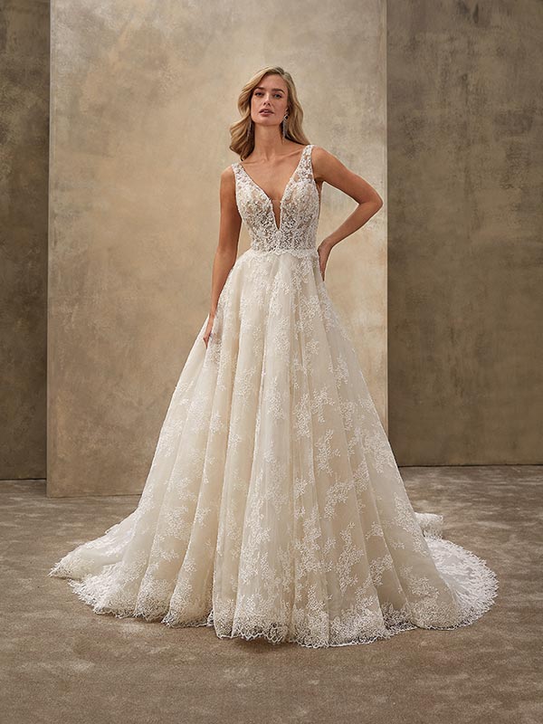 Eine blonde Frau in eleganter cremefarbener Spitzenrobe mit zurückhaltendem Lächeln