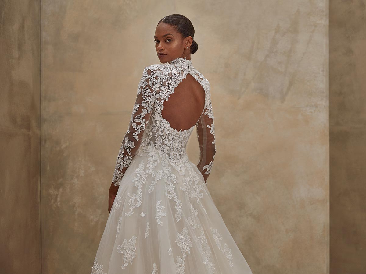 Eine elegant gekleidete Frau blickt ruhig über die Schulter in einem Spitzenkleid mit Rückenausschnitt