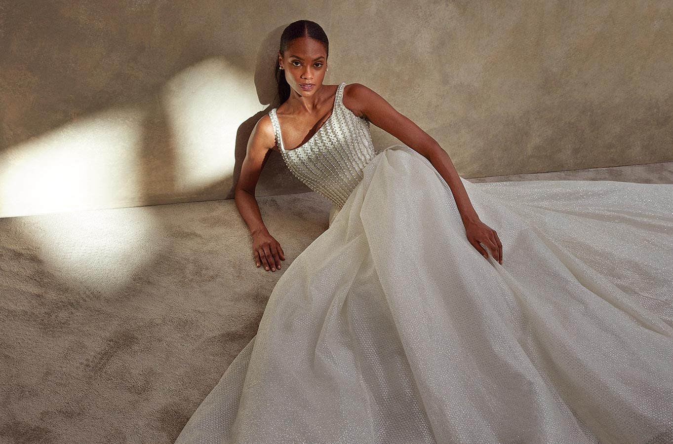 Eine elegante Frau mit ernster Miene trägt ein funkelndes weißes Abendkleid