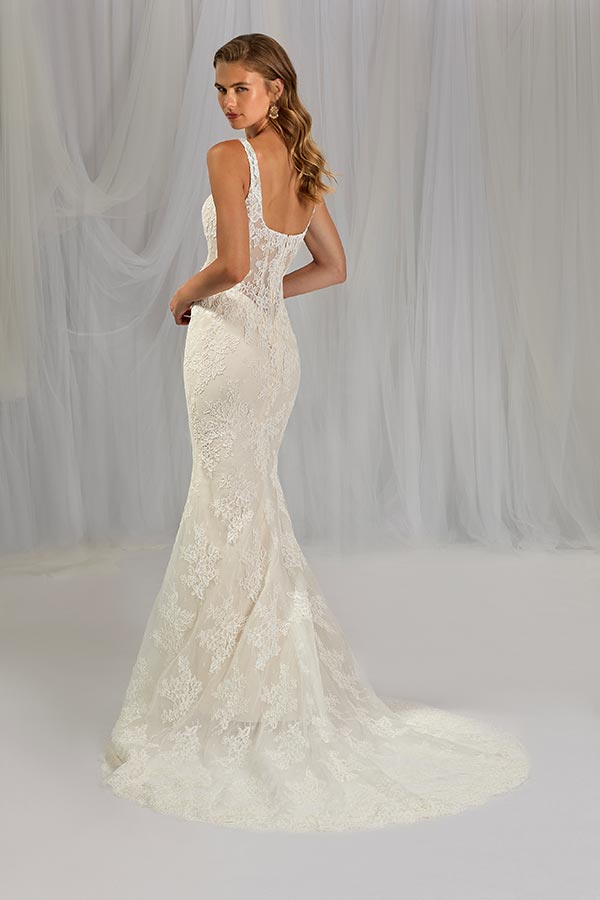 Junge Frau mit sanftem Lächeln trägt ein elegantes cremeweißes Spitzenkleid