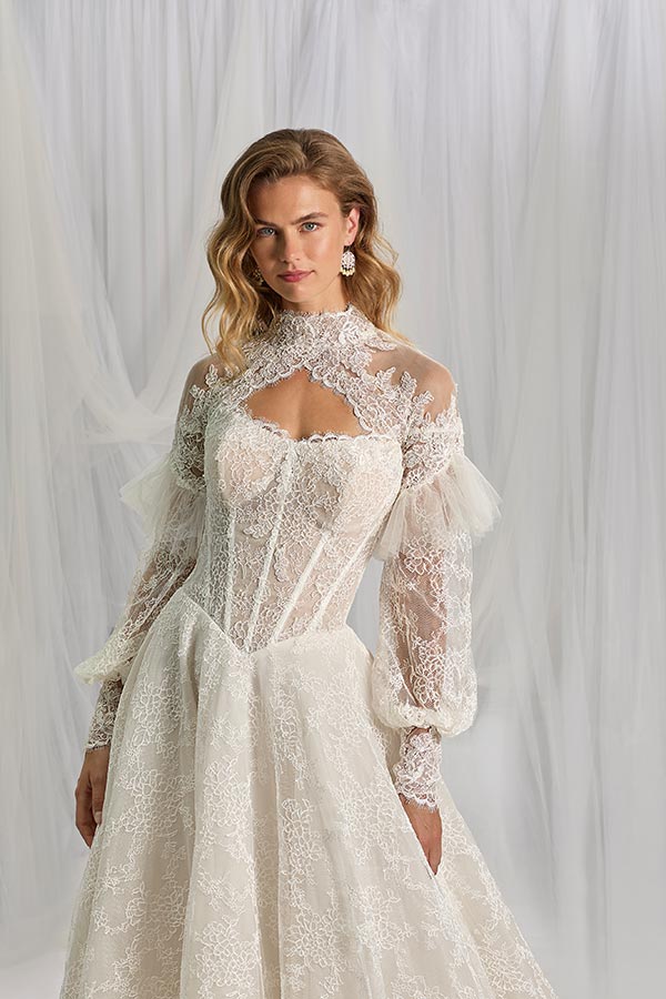 Junge Frau mit offenem Blick trägt ein elegantes Spitzenkleid in Weiß mit Puffärmeln