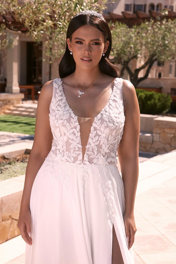 Junge Frau mit ernster Miene trägt ein weißes Spitzenkleid mit tiefem Ausschnitt