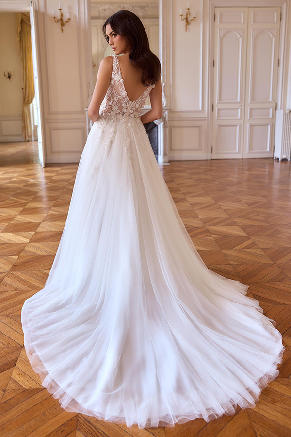 Eine brünette Frau in eleganter weißer Robe blickt ernst über die Schulter