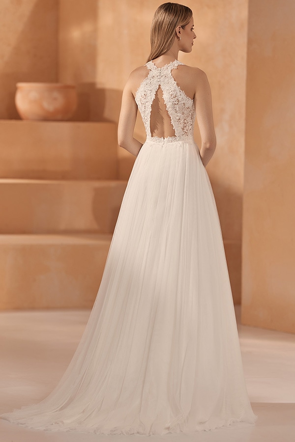 Eine junge Frau mit glattem blondem Haar trägt ein elegantes weißes Spitzenkleid