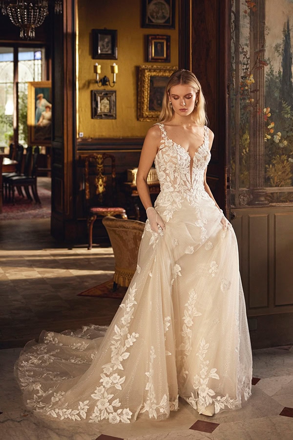 Eine blonde Frau im eleganten cremefarbenen Brautkleid mit floraler Spitze