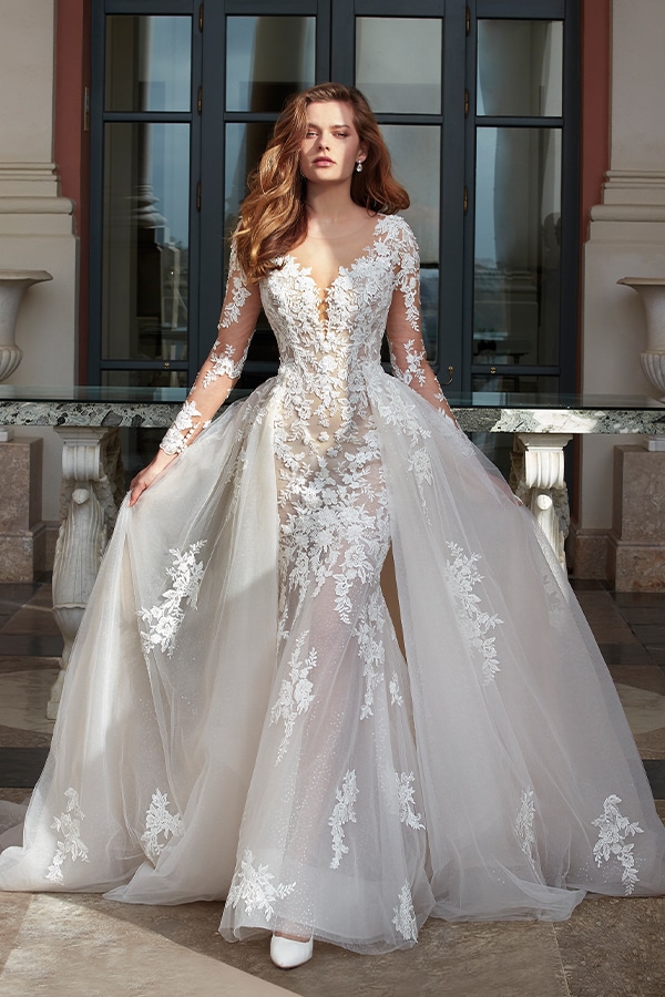 Eine junge Frau mit ernster Miene trägt ein elegantes weißes Spitzenkleid