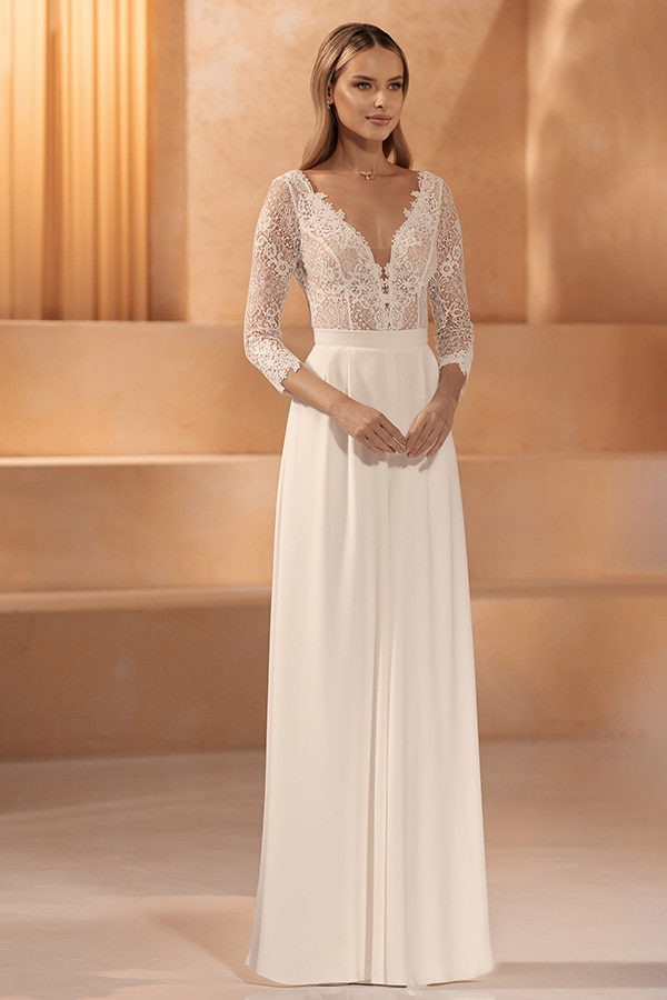 Eine junge Frau mit langen blonden Haaren trägt ein elegantes cremeweißes Kleid