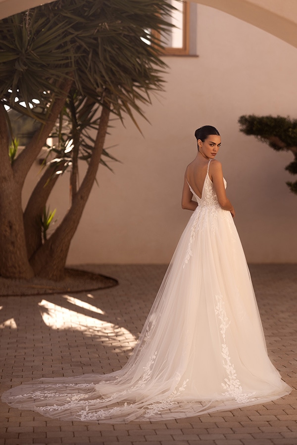 Eine Frau im eleganten weißen Brautkleid schaut ernst über die Schulter zurück