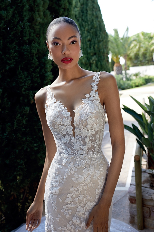 Elegante Frau mit neutralem Gesichtsausdruck in Spitzenkleid mit floralen Details und roten Lippen