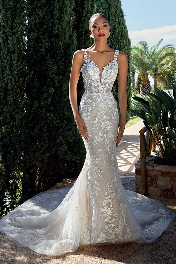 Eine elegante Frau mit rotem Lippenstift trägt ein figurbetontes Spitzenkleid in Weiß