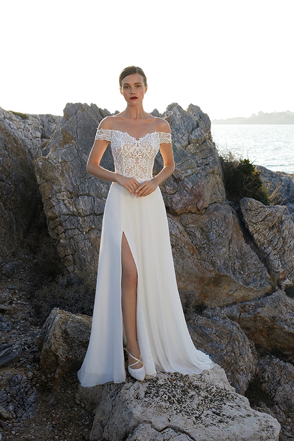 Eine Frau mit rotem Lippenstift trägt ein weißes Spitzenkleid am Felsenmeer