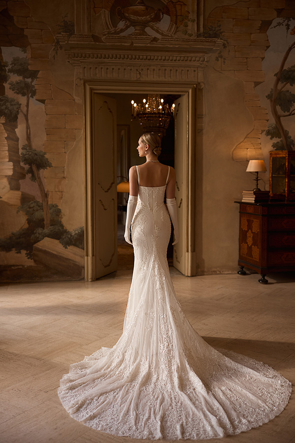 Eine blonde Frau im eleganten weißen Brautkleid steht in einem prunkvollen Saal