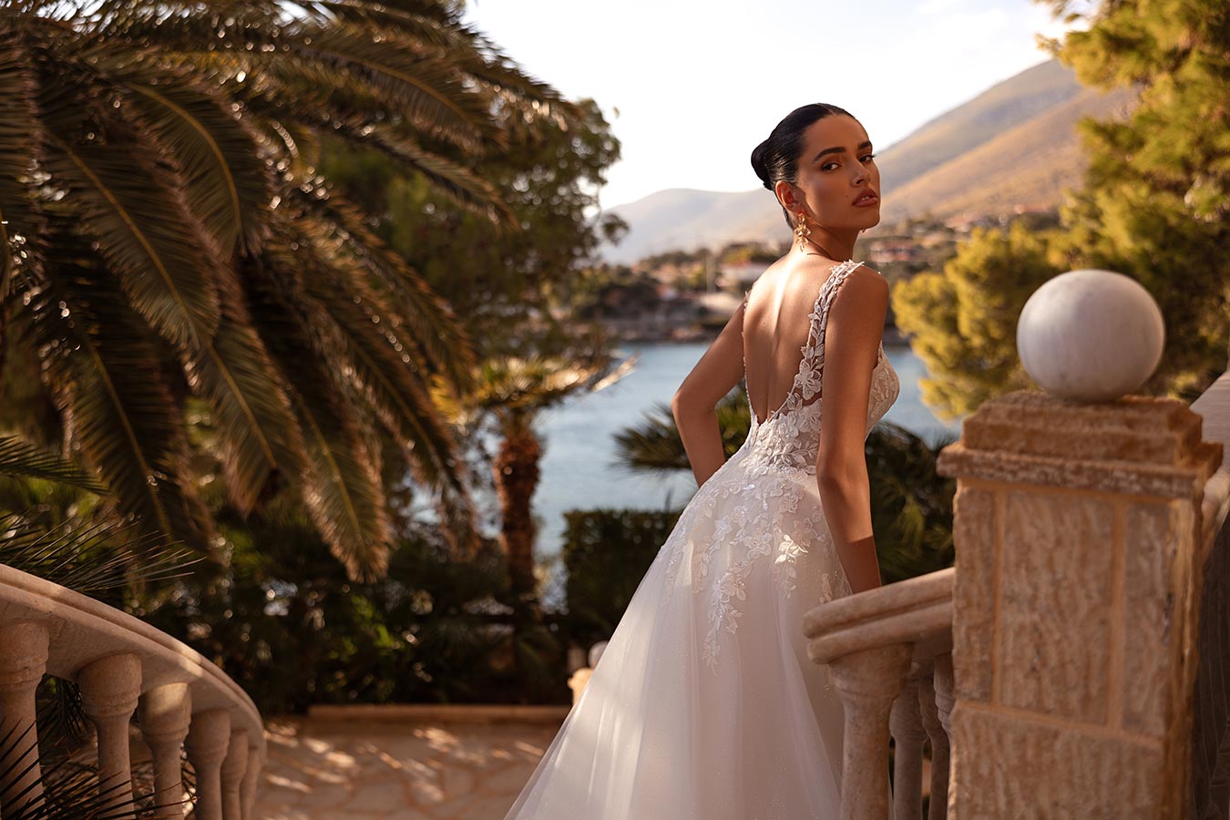 Eine Frau in einem eleganten weißen Brautkleid blickt nachdenklich zur Kamera