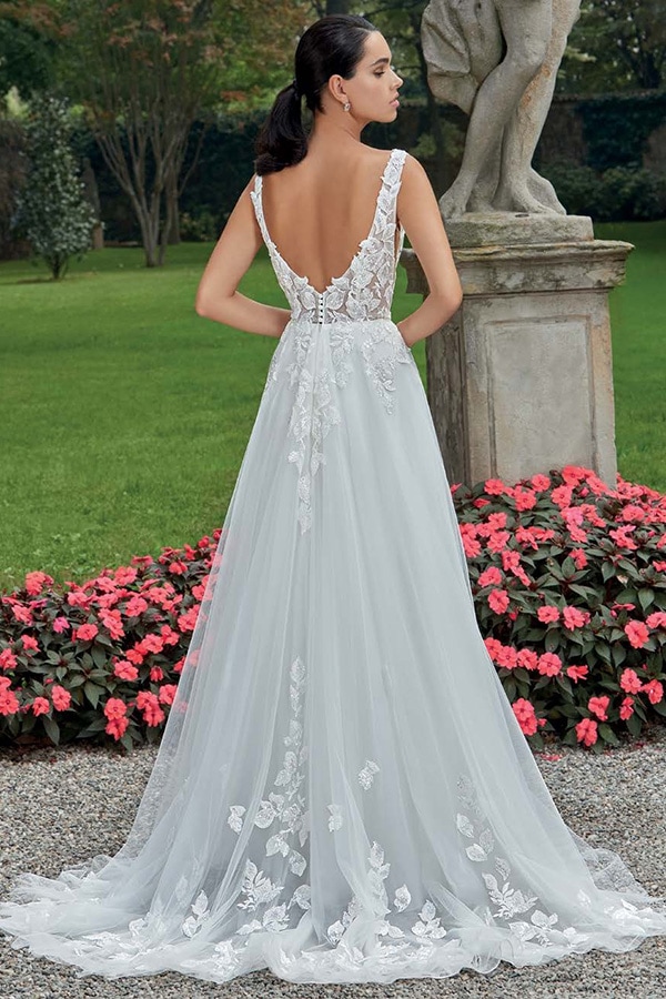 Eine Frau mit elegantem Gesichtsausdruck trägt ein weißes Brautkleid mit Spitzendetails