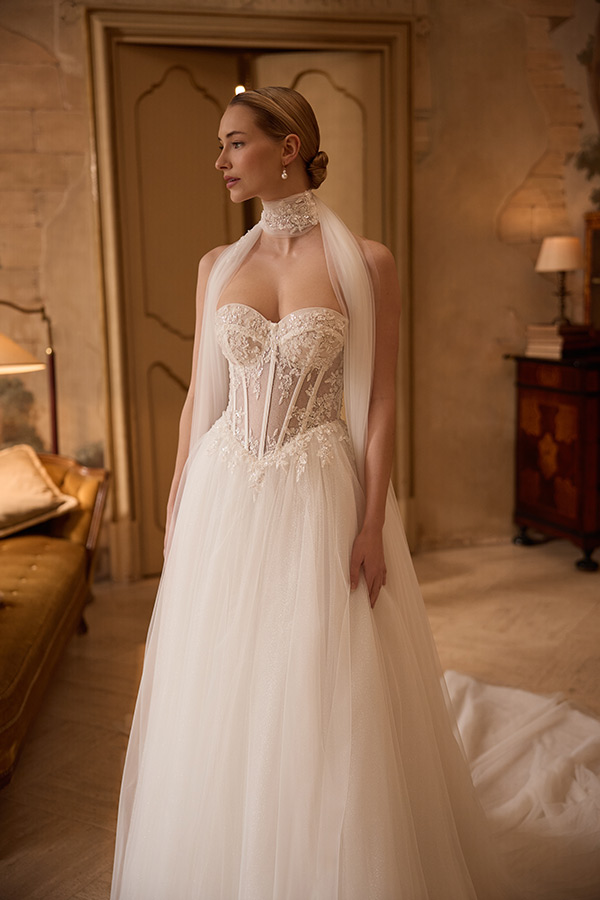 Junge Frau im weißen Brautkleid mit transparentem Mieder und Choker schaut nach links