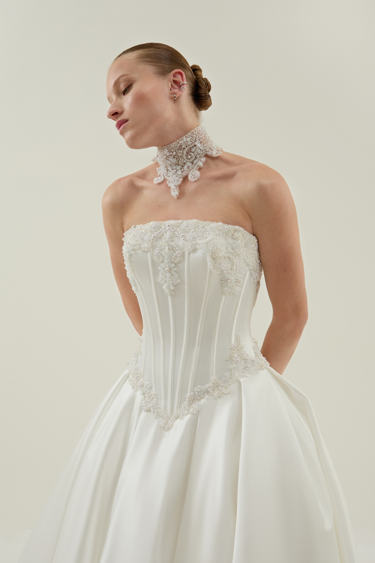 Junge Frau im weissen Brautkleid mit Perlenkorsett und Spitzenhalsband
